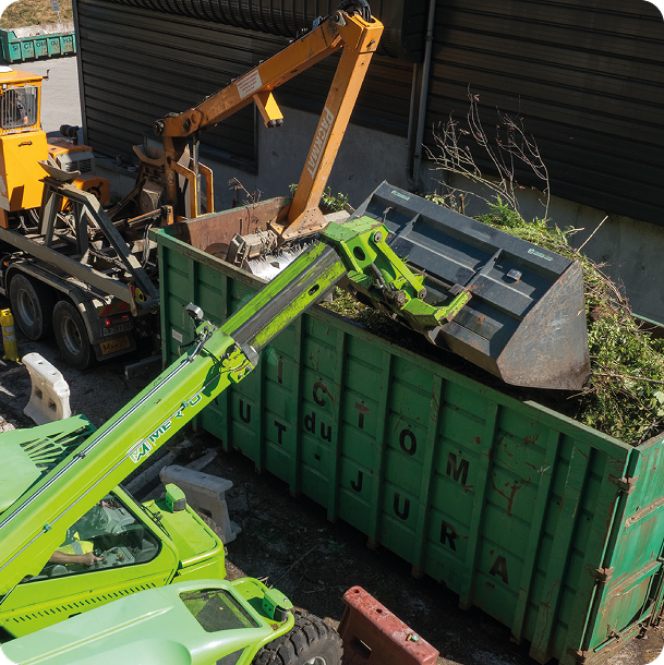 Photo de engin exerçant une pression pour compacter des déchets verts